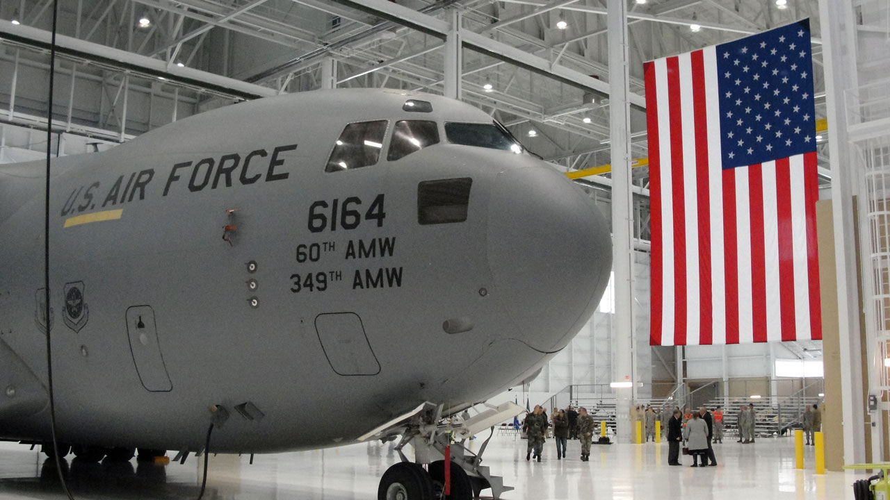 KC-10 advanced tanker and cargo aircraft in hangar with a United States flag hanging in the background