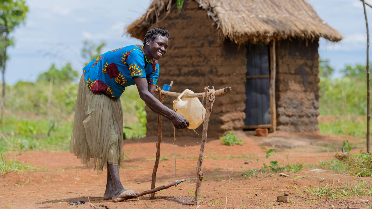 A woman washes her hands after using her household’s latrine in the Kitgum district of Uganda where a Tetra Tech-led water and sanitation project has increased access to latrines and handwashing stations