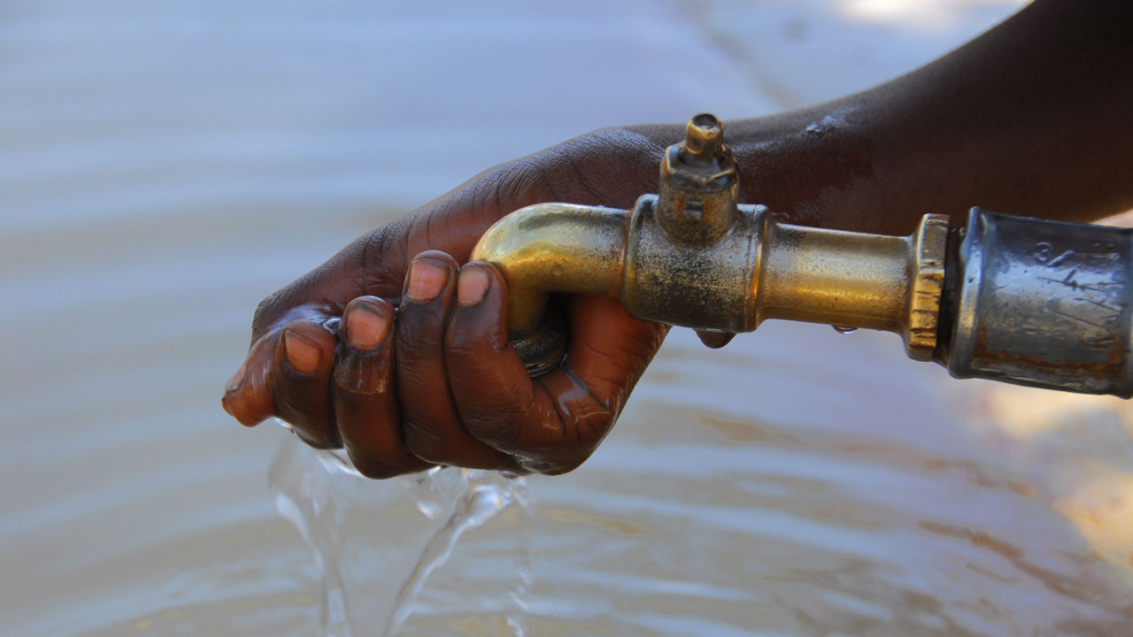 Hand cupped beneath faucet with clean water flowing