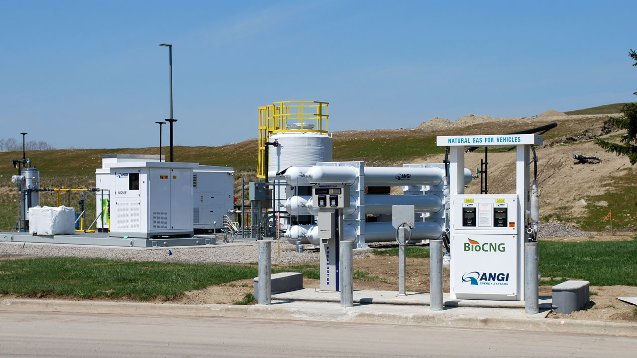 View of a BioCNG fueling station with a hill and blue sky in the background