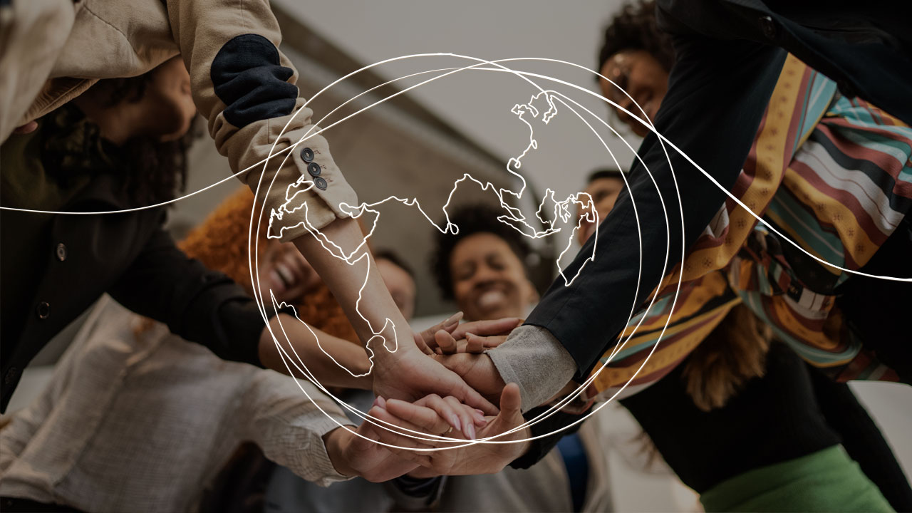 A line drawing of a global over a photo of a diverse group of people with their hands in the middle of the group in a hand stack