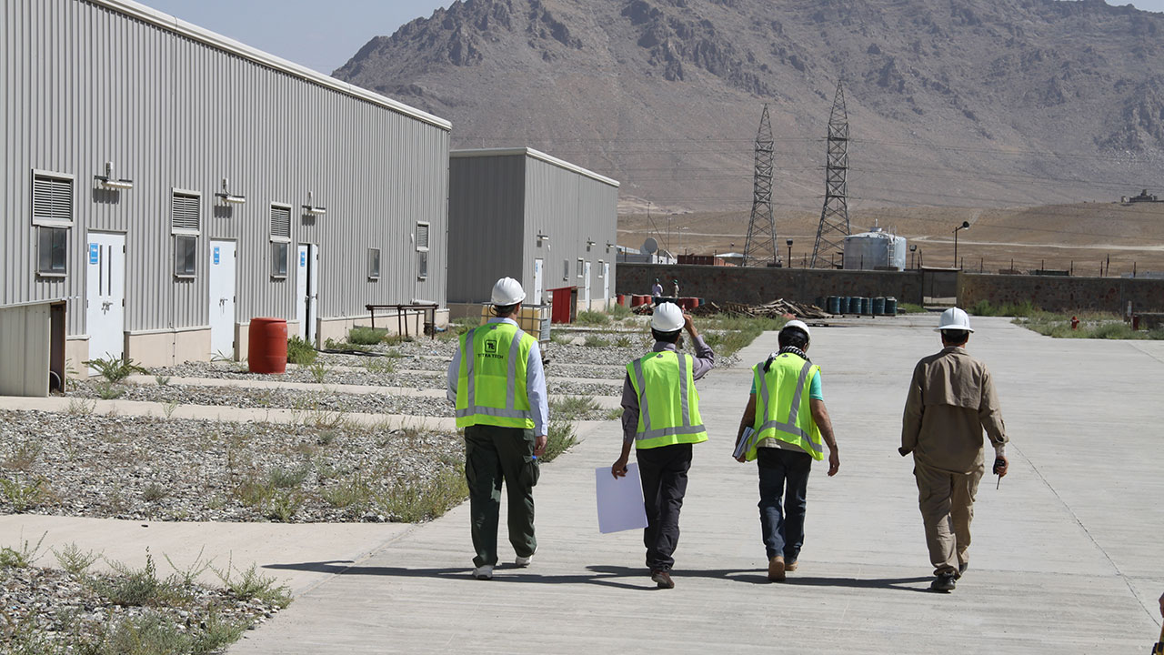Four Tetra Tech staff are walking together on site at an electrical engineering project