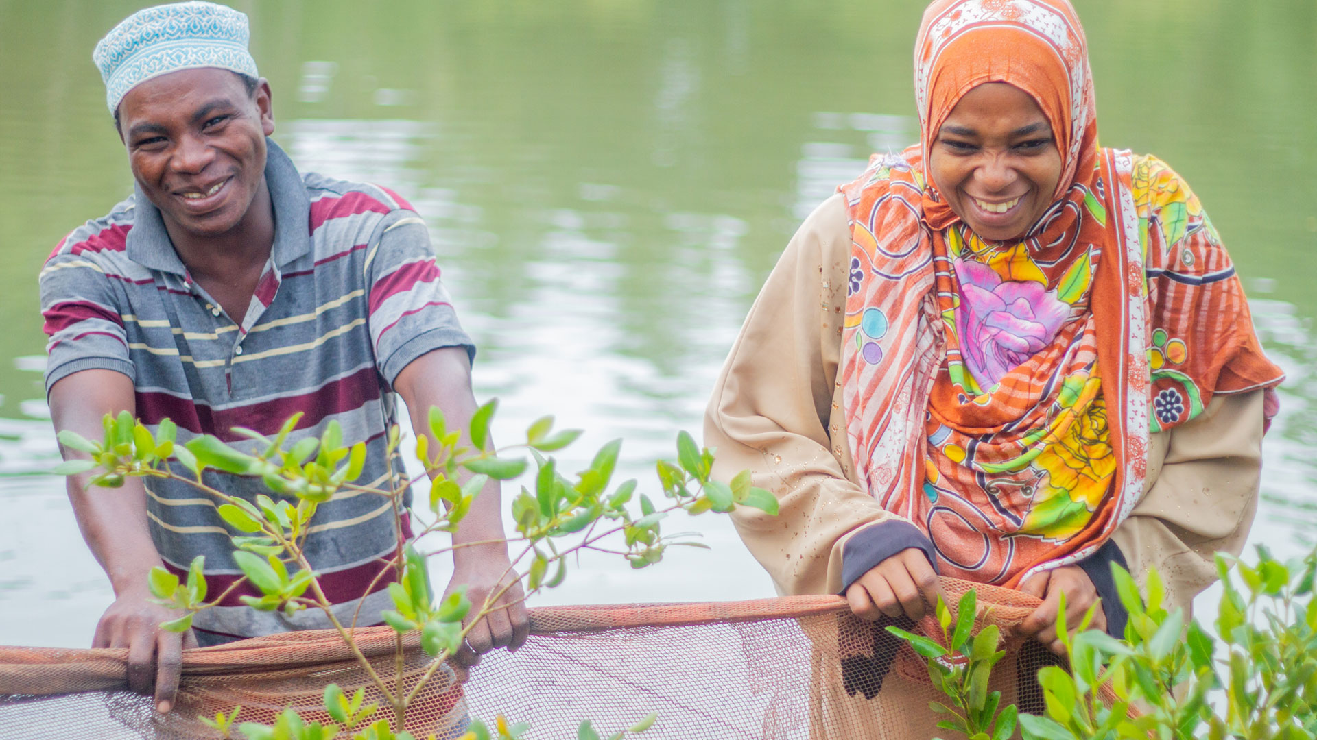 A male and female member of a youth group supported by the project work together on their aquaculture project in Pemba, Zanzibar