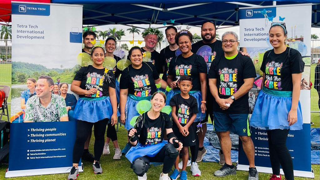 Tetra Tech’s team stand beside the company’s pavilion at the Frank Hilton Organization’s annual wheelbarrow race fundraising event