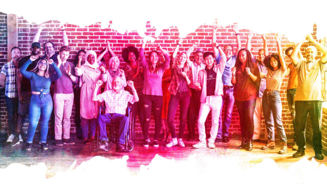A diverse group of people stand against a brick wall with a transparent rainbow colour overlay