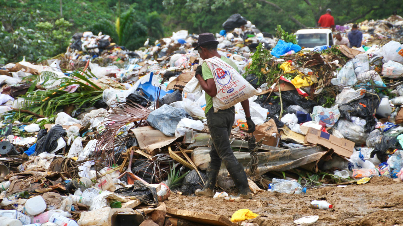 A wastepicker walking through a dump site looking for recyclables