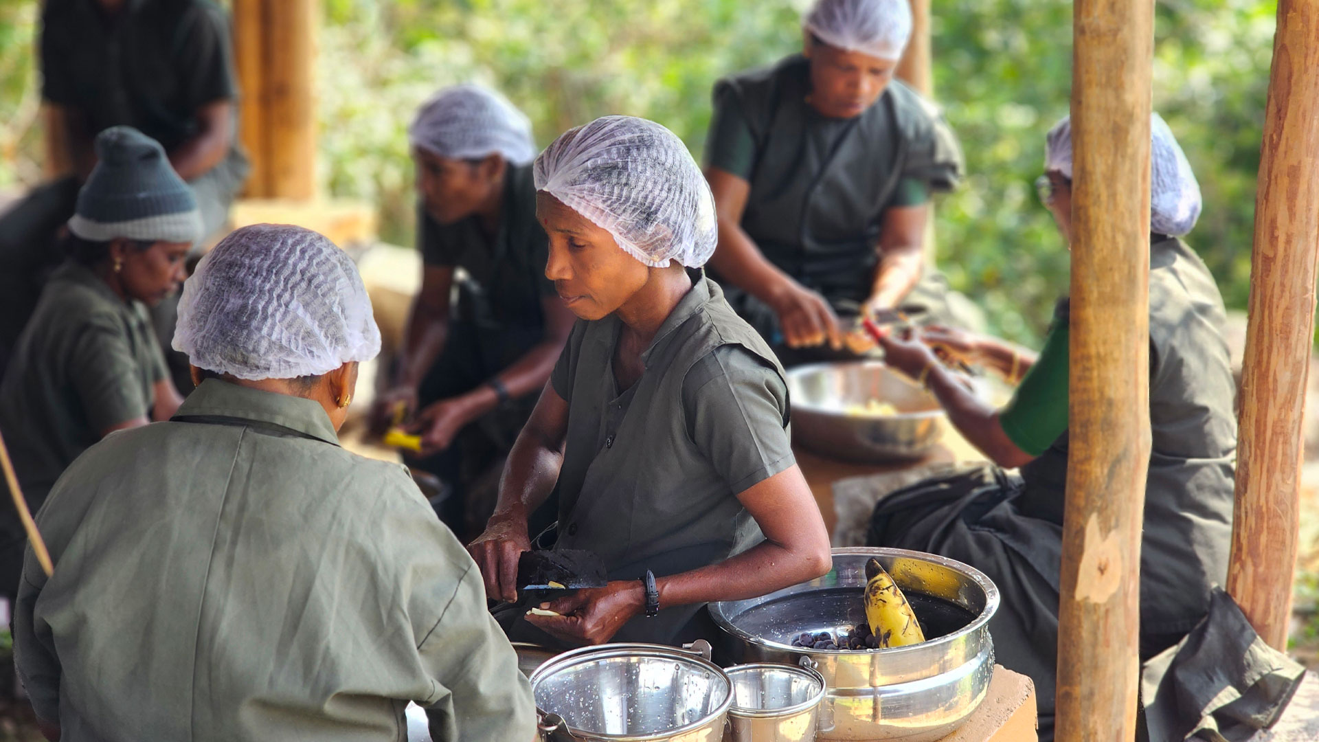 A group of people wearing hair nets peeling food representing the ‘Food from the Forest’ initiative, which promotes the traditional food systems of the indigenous Kani community