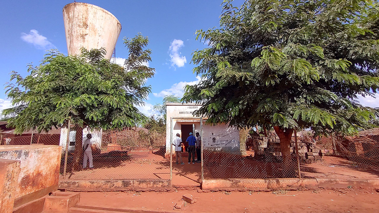 Four people standing in front of a local water supply system operation center in Meti