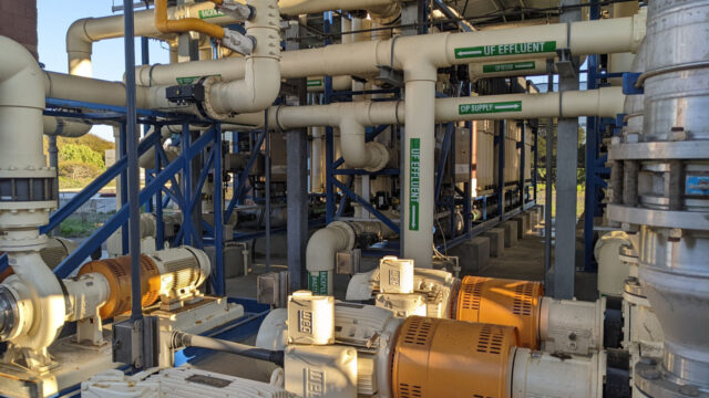 A network of pipes and pumps is seen in a water reclamation facility, with directional signs indicating various water flows