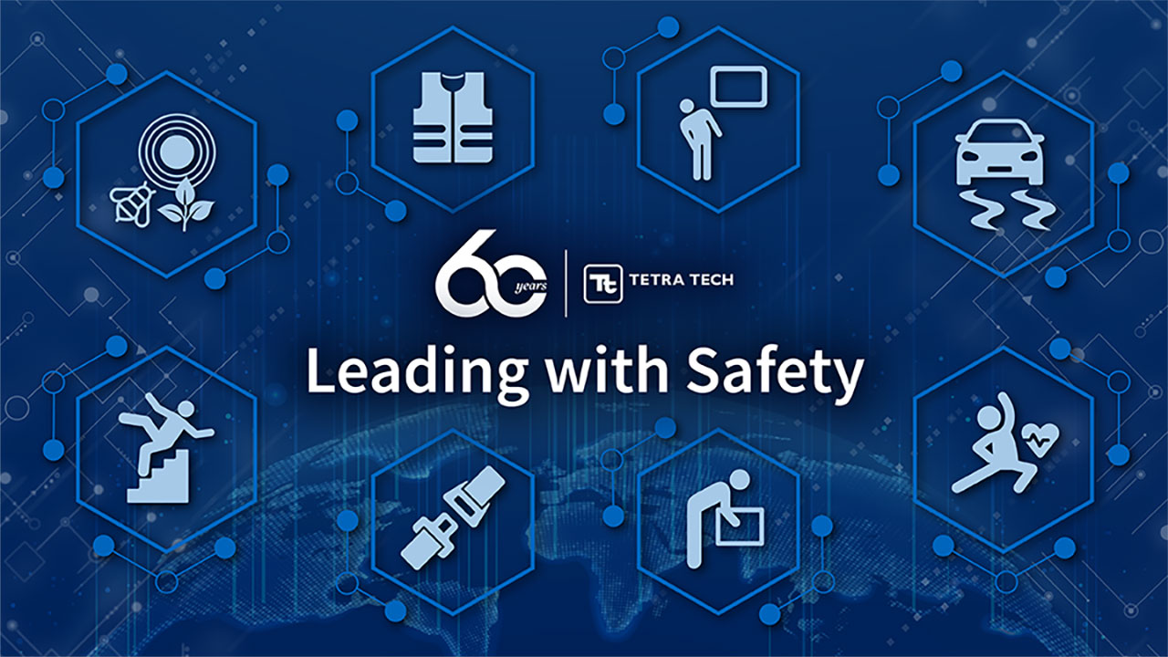 Blue graphic with health and safety icons and the words “Leading with Safety”