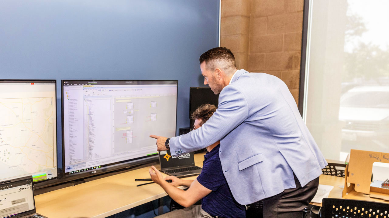 Luke Stephenson discussing with a colleague in front of a monitor