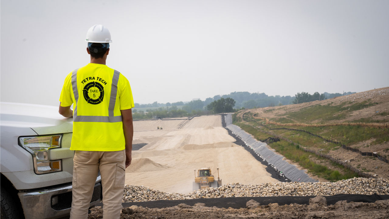 Tetra Tech employee standing across a new cell at a landfill
