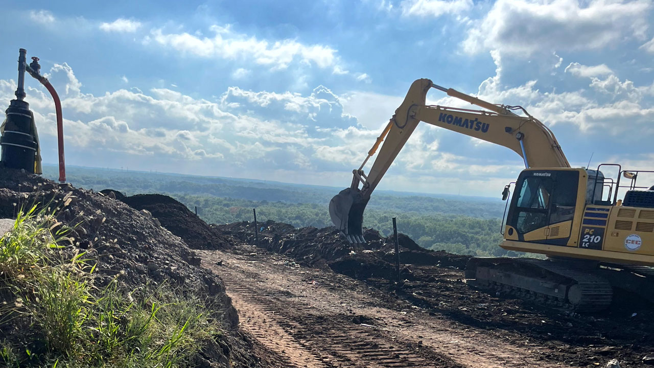 Tetra Tech field team conducting landfill gas well installation with safety barricades and monitoring equipment in place