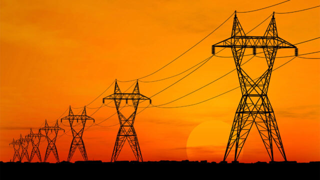 Power grid pylons against a sunset