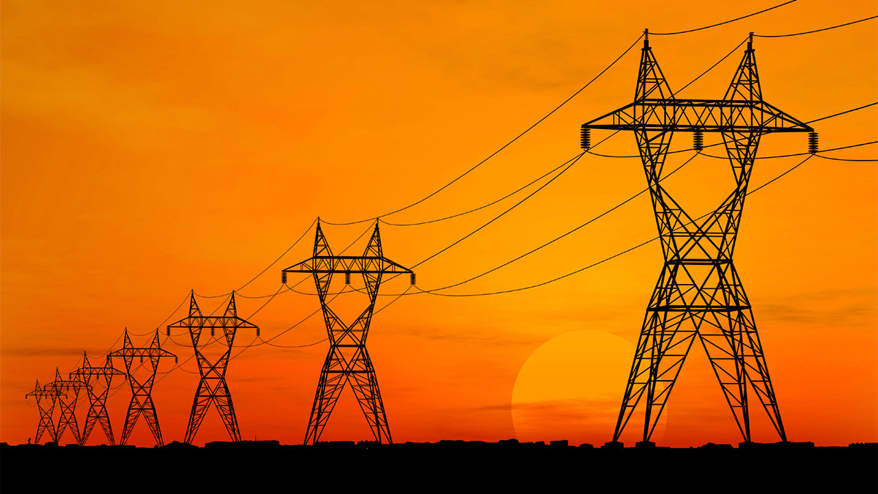 Power grid pylons against a sunset
