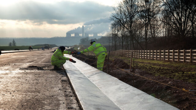 Two workers complete road drainage works