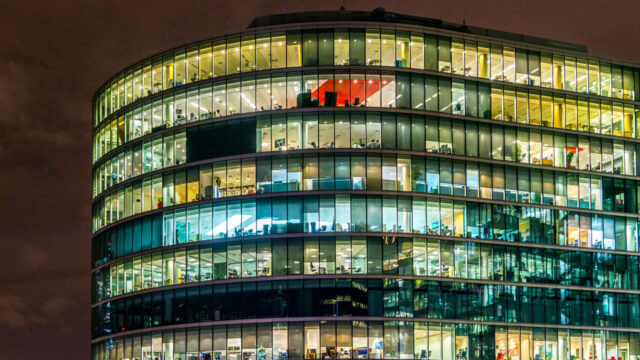 view of a building at night with various floors or stories lit up