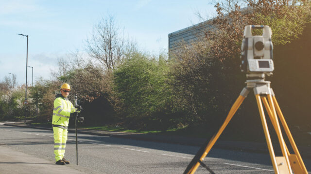 Man conducting a geospatial survey on a road