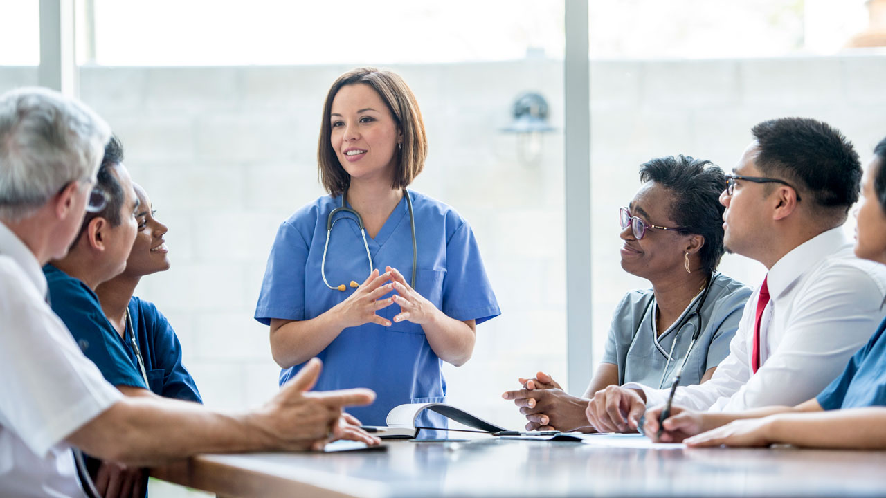 Occupational nurse talks to a group of business people 