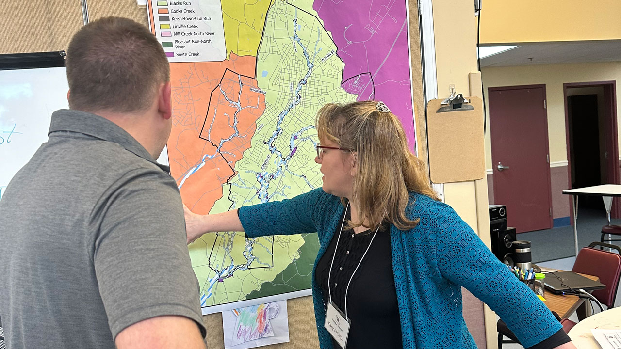 Tetra Tech's Kary Phillips uses a paper map to conduct watershed engagement with a stakeholder at a community workshop in Harrisonburg, Virginia