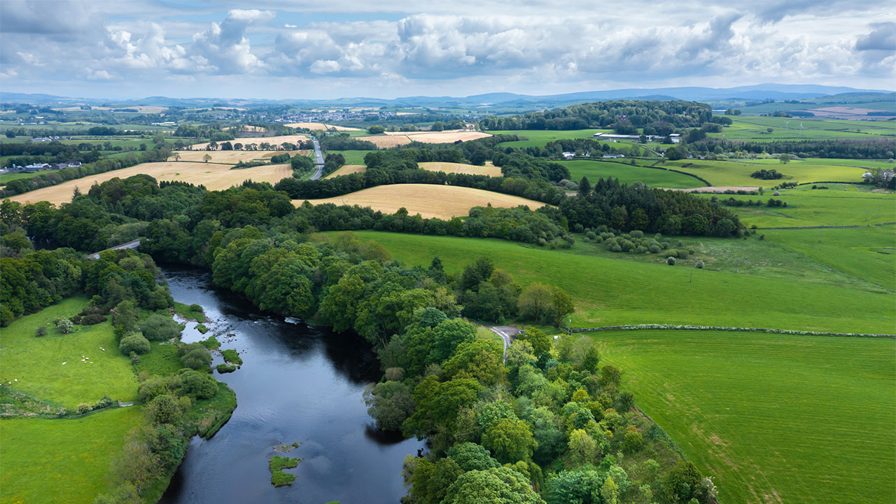 High angle view from a drone of a Scottish river flowing through a rural location in early summer