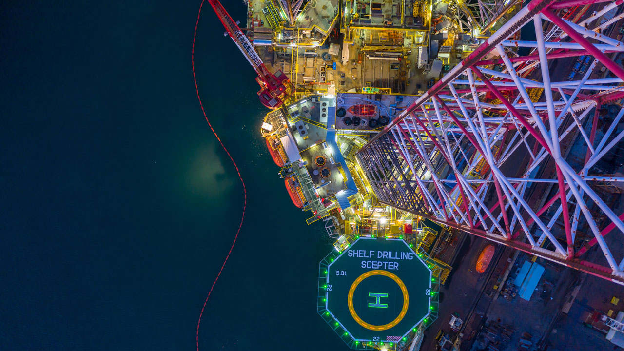 Aerial view of offshore jack-up rig at night for offshore oil rig drilling platform