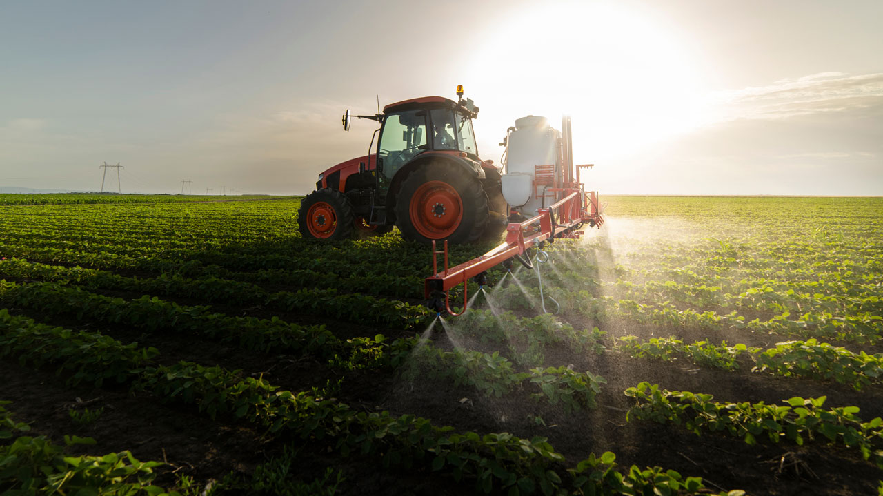 Tractor spraying pesticides in a field