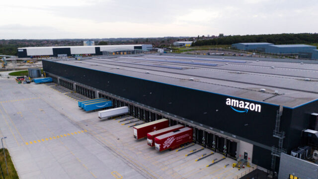 Aerial view of an Amazon distribution center featuring loading docks and delivery trucks parked outside