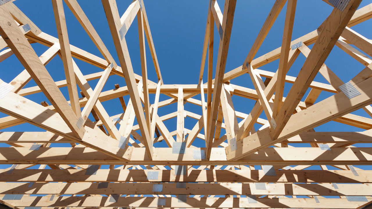 Ground view of intricate wooden scaffolding showing a clear blue sky above