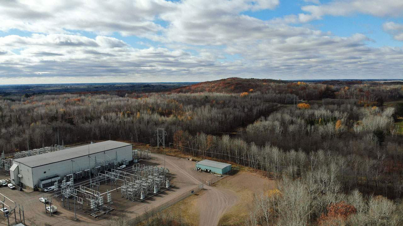 A large electricity substation surrounded by forested land