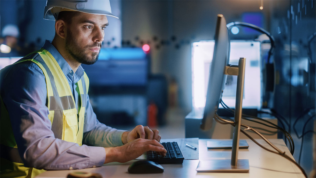 Engineer Wearing Safety Vest Working on Computer, Developing Industrial Microchips, Semiconductor, Manufacturing Processors
