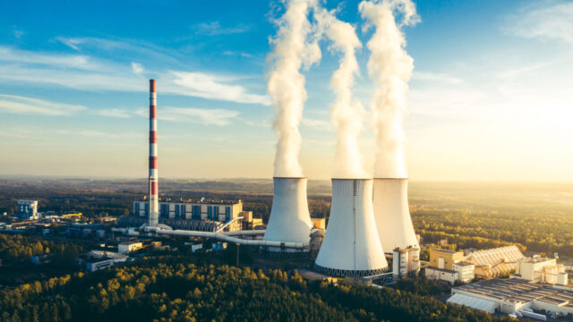 Aerial view of industrial chimney stacks with smoke