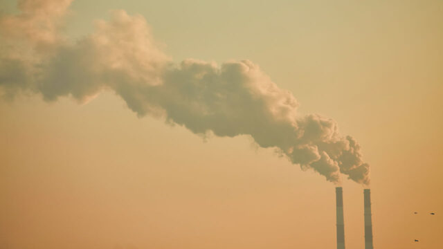 Industrial chimney stacks with smoke plumes