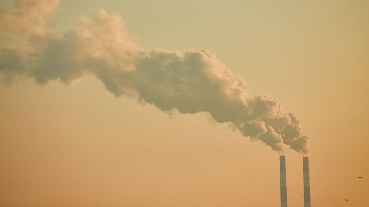 Industrial chimney stacks with smoke plumes