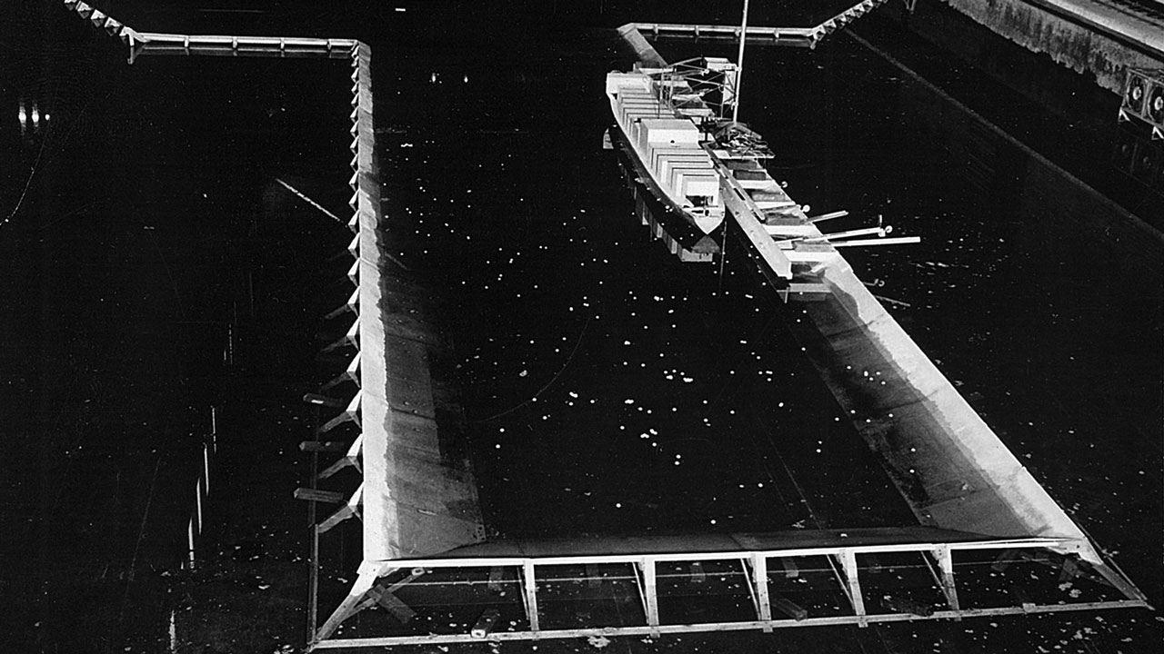 A front view of a docking area with a model ship in the Tetra Tech wave lab