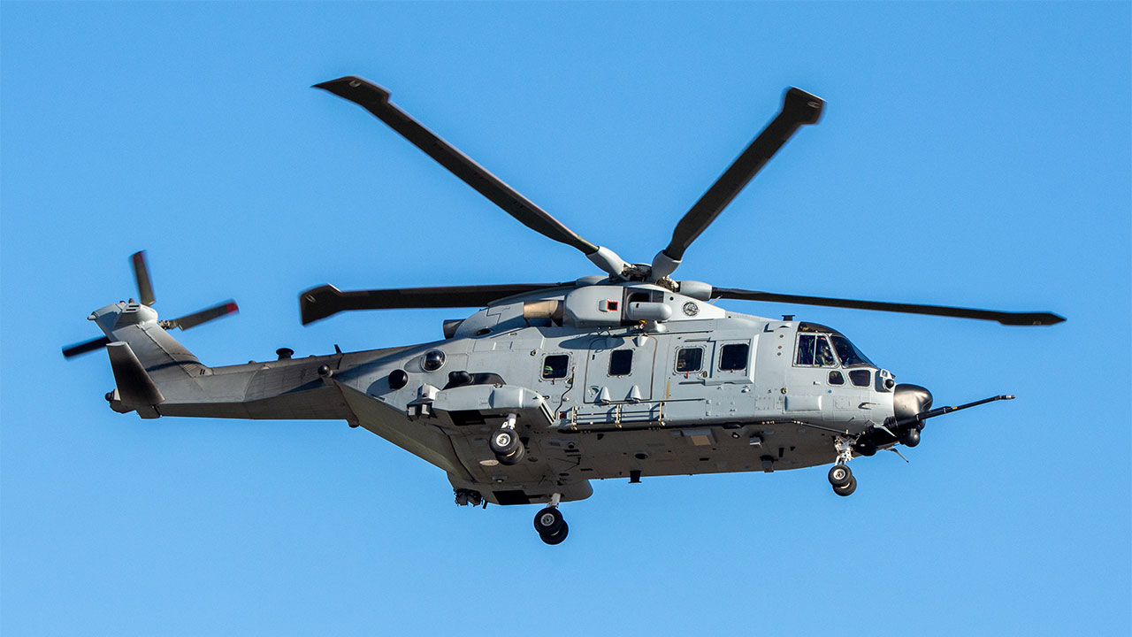 Military helicopter in flight against a blue sky