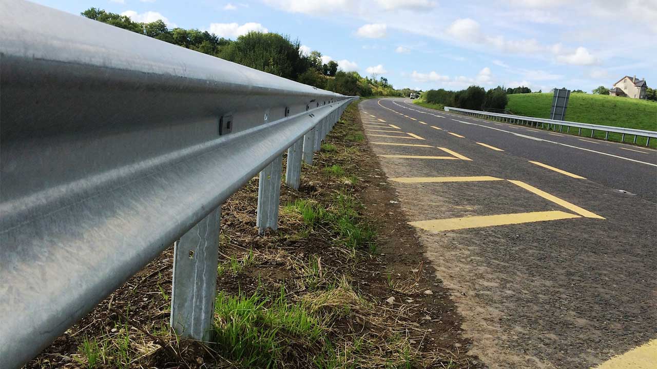 A metal guardrail running alongside a paved road