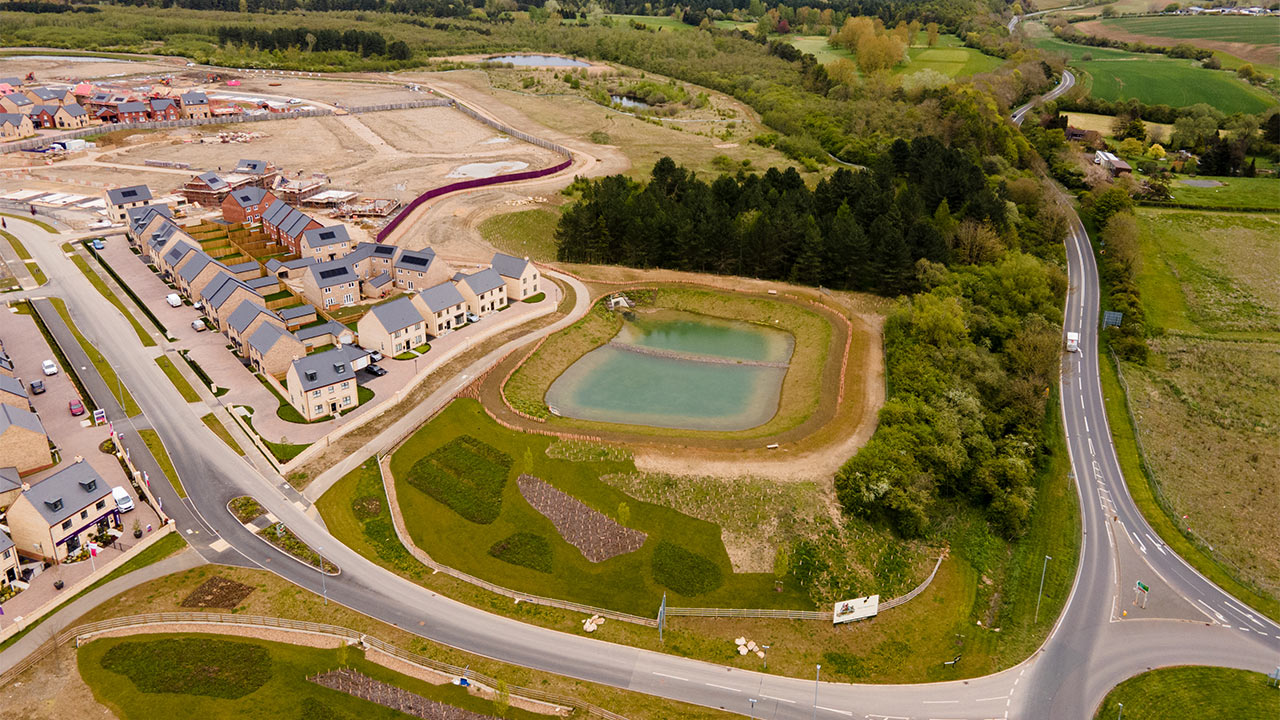 High level view of housing development alongside road and drainage infrastructure