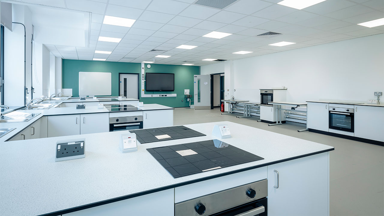 Render image of a classroom with tables and ovens