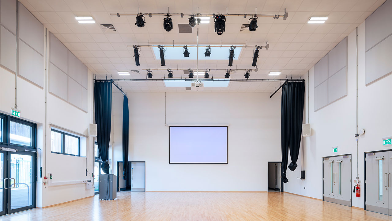 Render of a gymnasium with a projector screen mounted on the wall with theatre lights