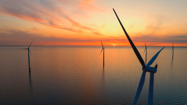 Aerial view of wind turbines against a sunset sky