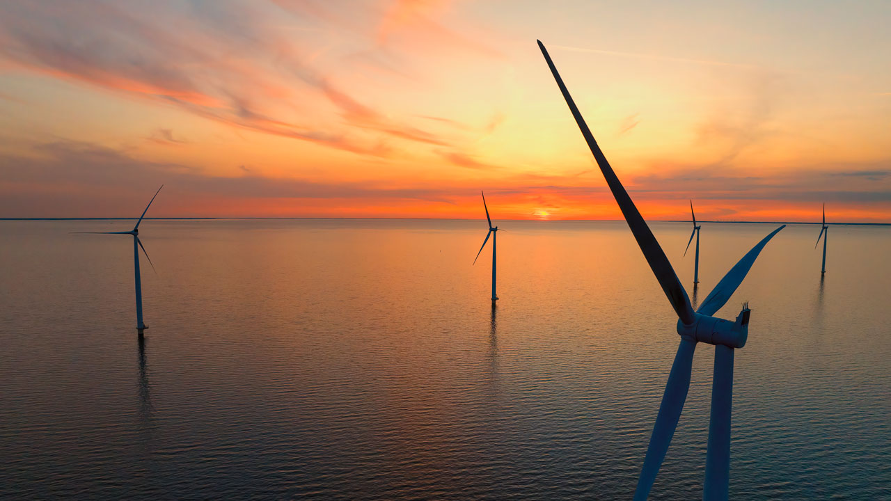 Aerial view of wind turbines against a sunset sky
