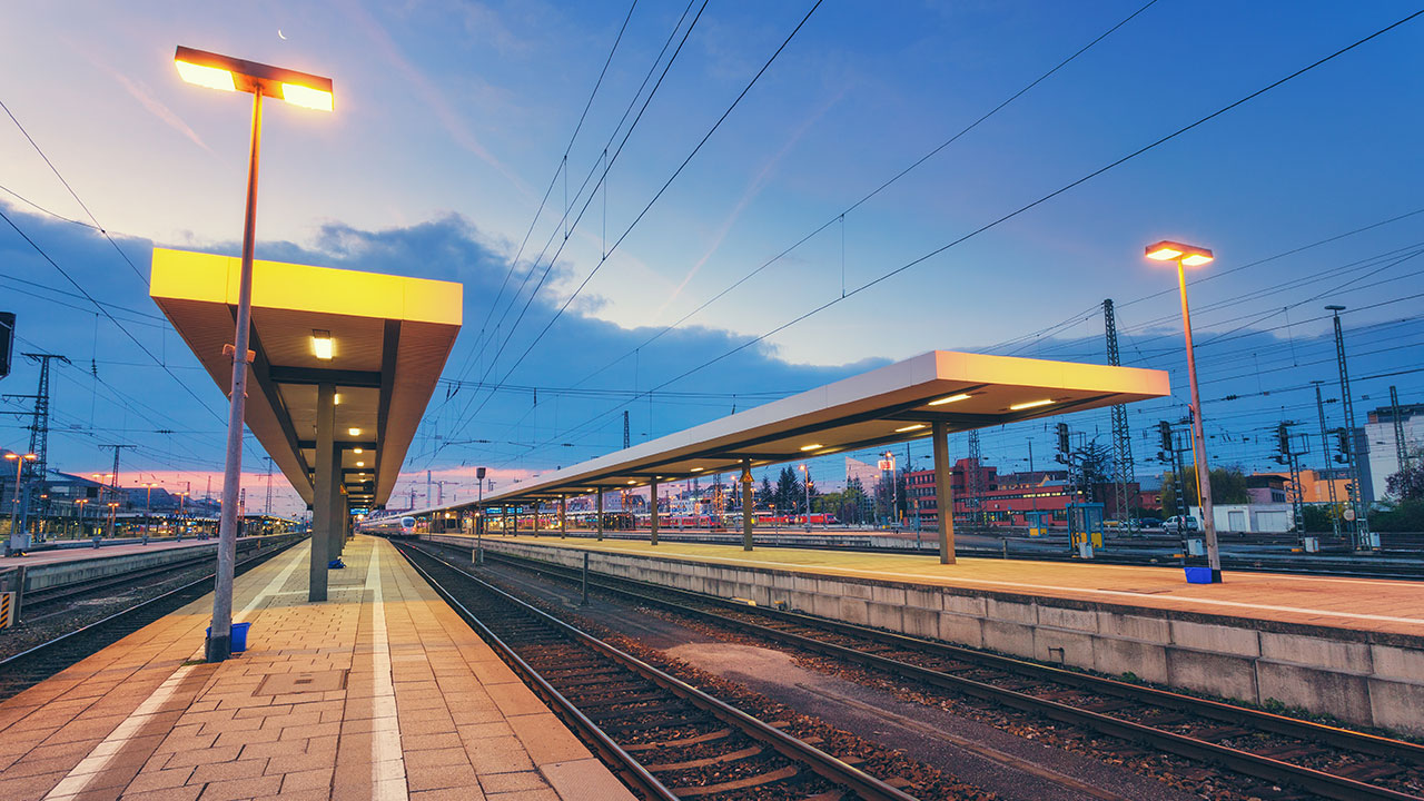 Render image of an empty local railway station illuminated at dusk