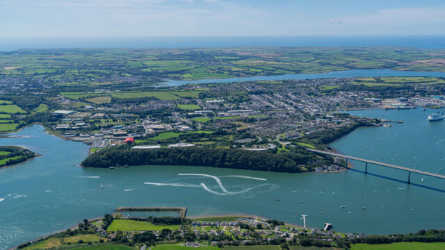 Aerial view of a waterway surrounded by a town and farmland