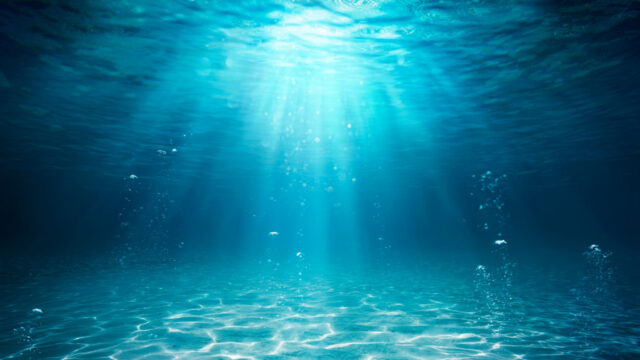 Sunlight shining through the sea from under water making a pattern on the seabed