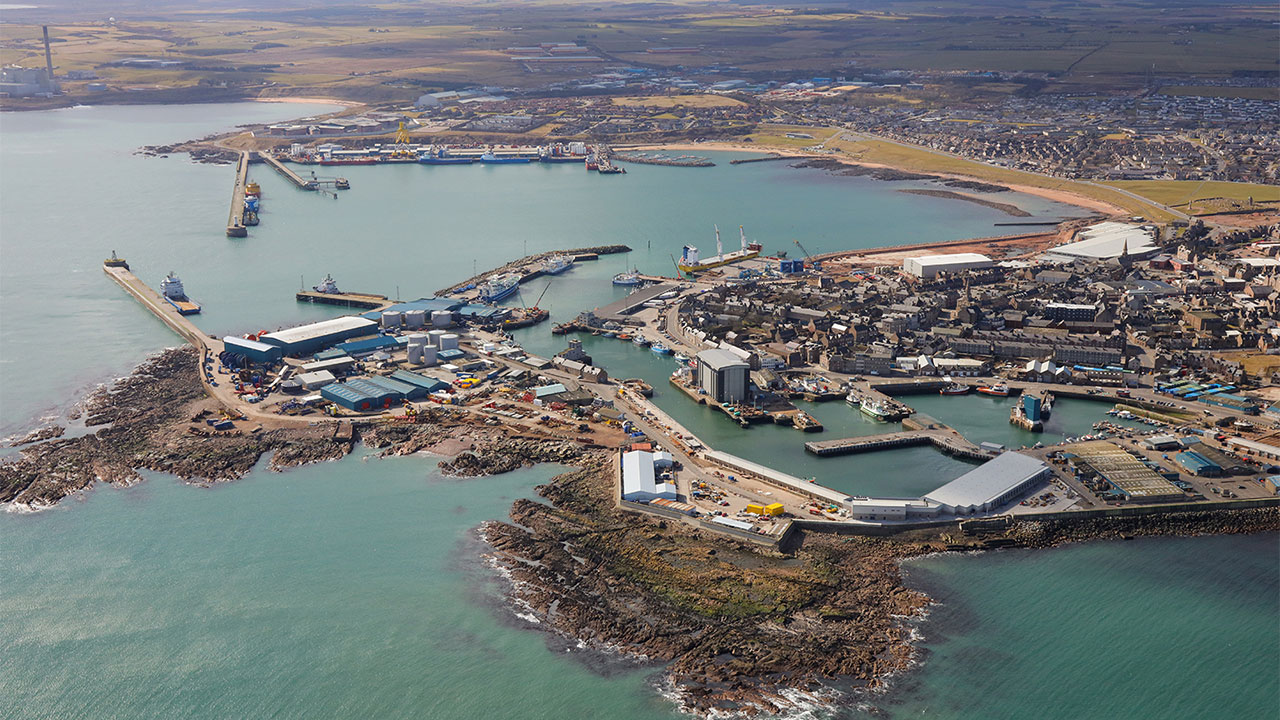 An aerial view of Peterhead Harbour and industrial buildings, with ships on the water and at quaysides