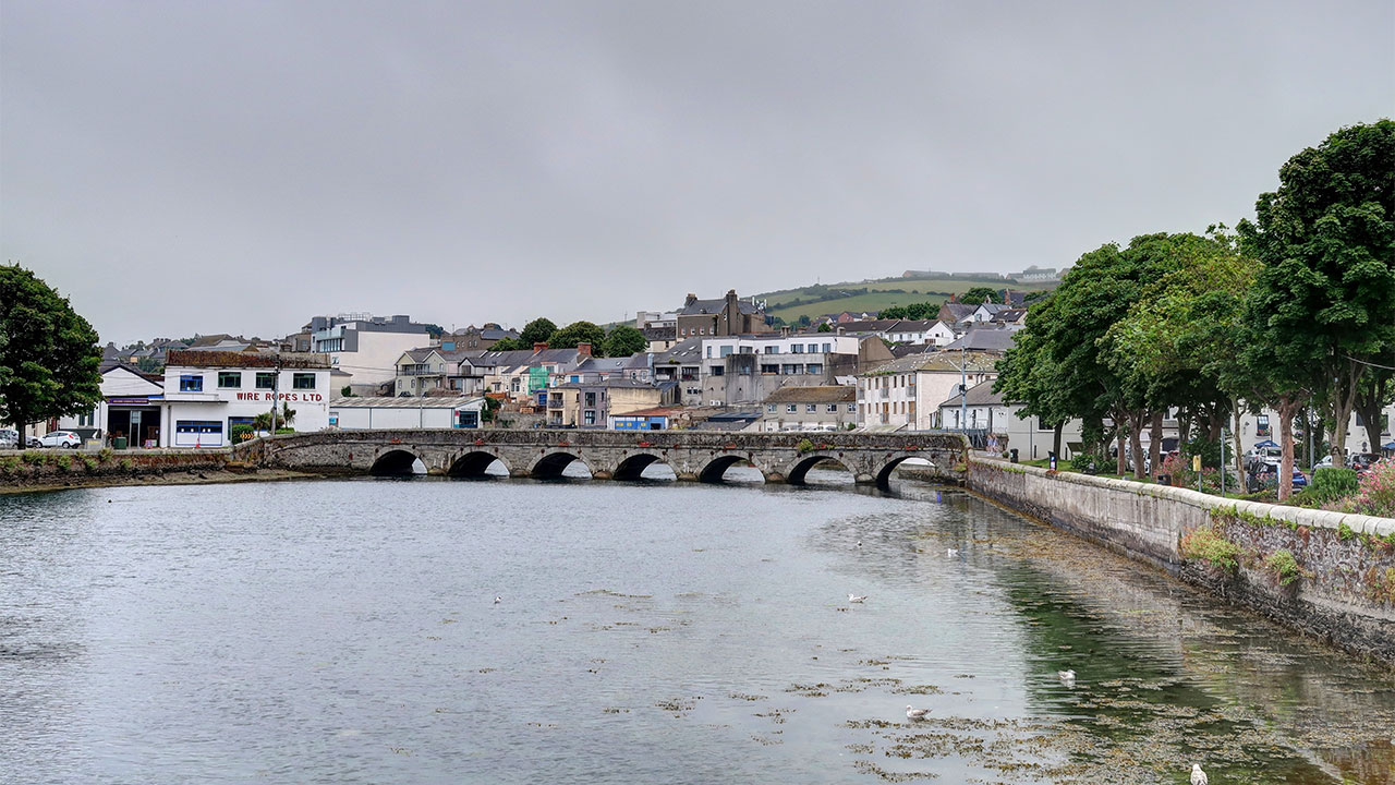 Photograph of a bridge over water into an urban area