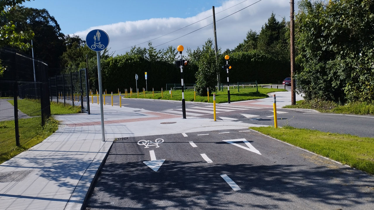 A close up photograph of a Dutch-style junction accommodating the safe travel of pedestrians, cyclists and vehicle drivers