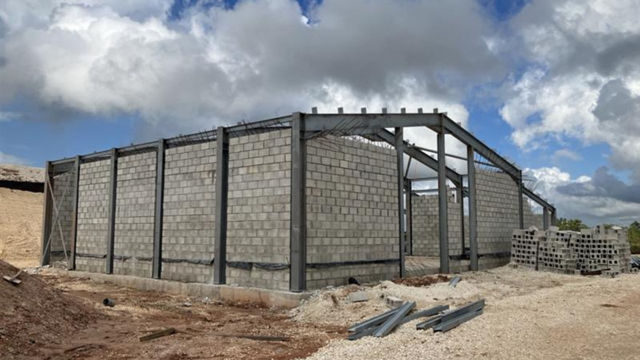 A partially constructed building with concrete block walls and a metal frame