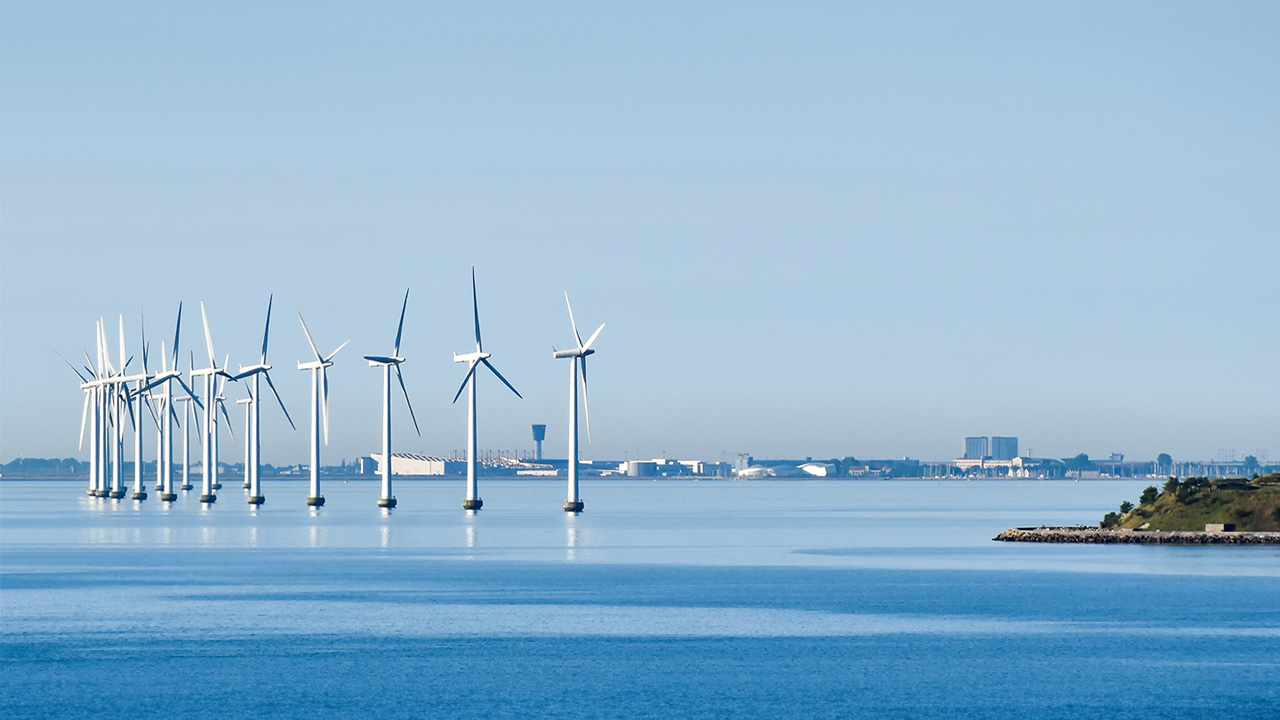 A view of offshore wind turbines against a calm sea
